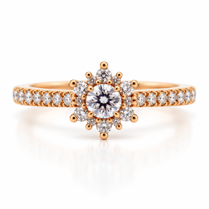 A rose gold engagement ring featuring a central round-cut diamond surrounded by a halo of smaller diamonds, with a pavé band, set against a clean white background with a soft reflection.
