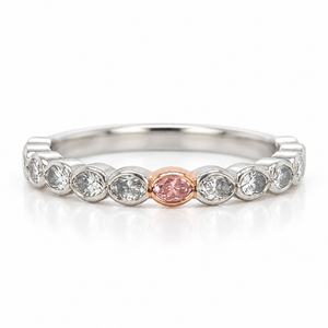 A silver-toned eternity ring featuring a row of clear oval diamond with a single rose gold oval center stone, shown on a white background with a soft reflection.